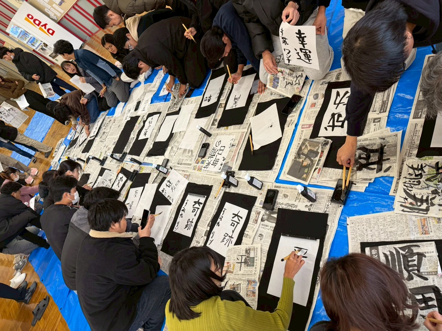 仲間と書き初めに取り組む学生たち
